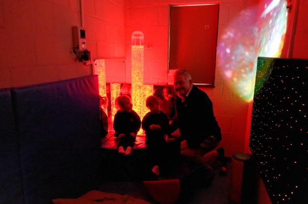 Lion President John Gee with two children in the Sensory Room
